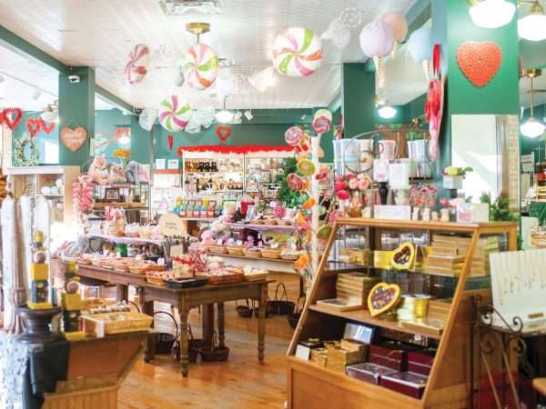 Interior shot of The Candy Factory, showcasing shelves and stacks of colorful candy throughout the store.