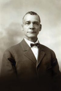 Sepia colored headshot of Tom Bass