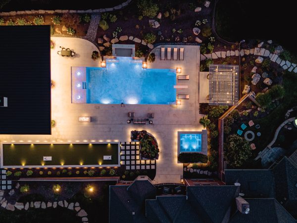 aerial view of a home with a pool in the backyard with string lights on at night