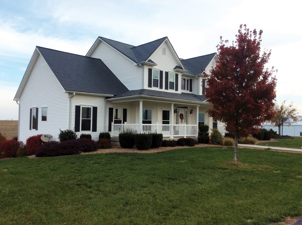 A white house with a metal shingle roof