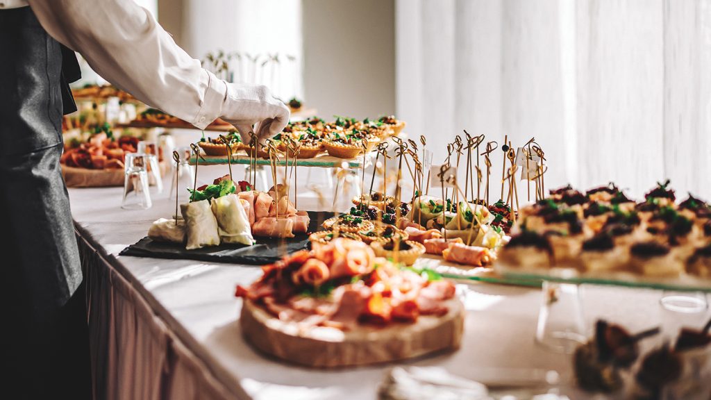 female hands of a waiter prepare food for a buffet table in a restaurant