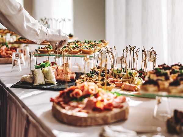 female hands of a waiter prepare food for a buffet table in a restaurant