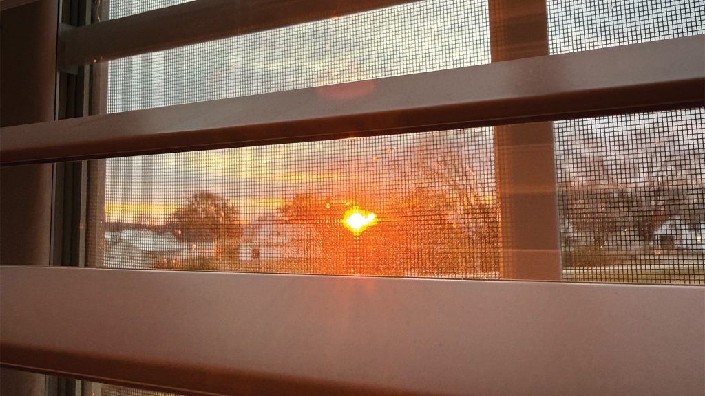 A bright orange sunset paints the midwestern sky — the view from our Airbnb.