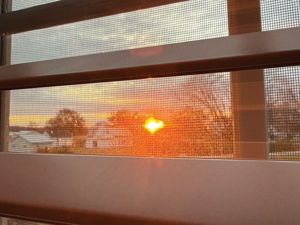 A bright orange sunset paints the midwestern sky — the view from our Airbnb. 