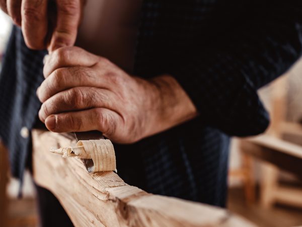 Hands of a carpenter working with chisel and hammer